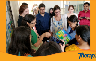 a special need child in Autism Welfare Foundation showing her own drawing to Therap team members